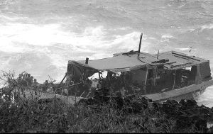 撞崖　偷渡船被巨大的海浪抛向崖壁。