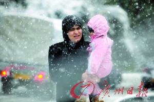 恨雪　　16日，在阿尔及利亚，一名妇女在暴雪中抱着孩子。