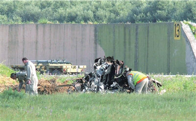 23日，救援专家检查坠毁飞机的残骸。