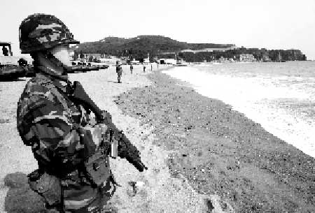 27日,韩国海军陆战队队员在沉船海域附近海滩巡逻。
