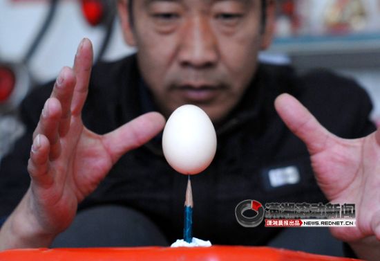 1月16日，长沙红星大市场，崔师傅凝神屏气，让鸡蛋“站立”在了铅笔头上。图/潇湘晨报滚动新闻记者 沈荣华