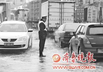 杨明星站在积水中指挥交通。(视频截图)